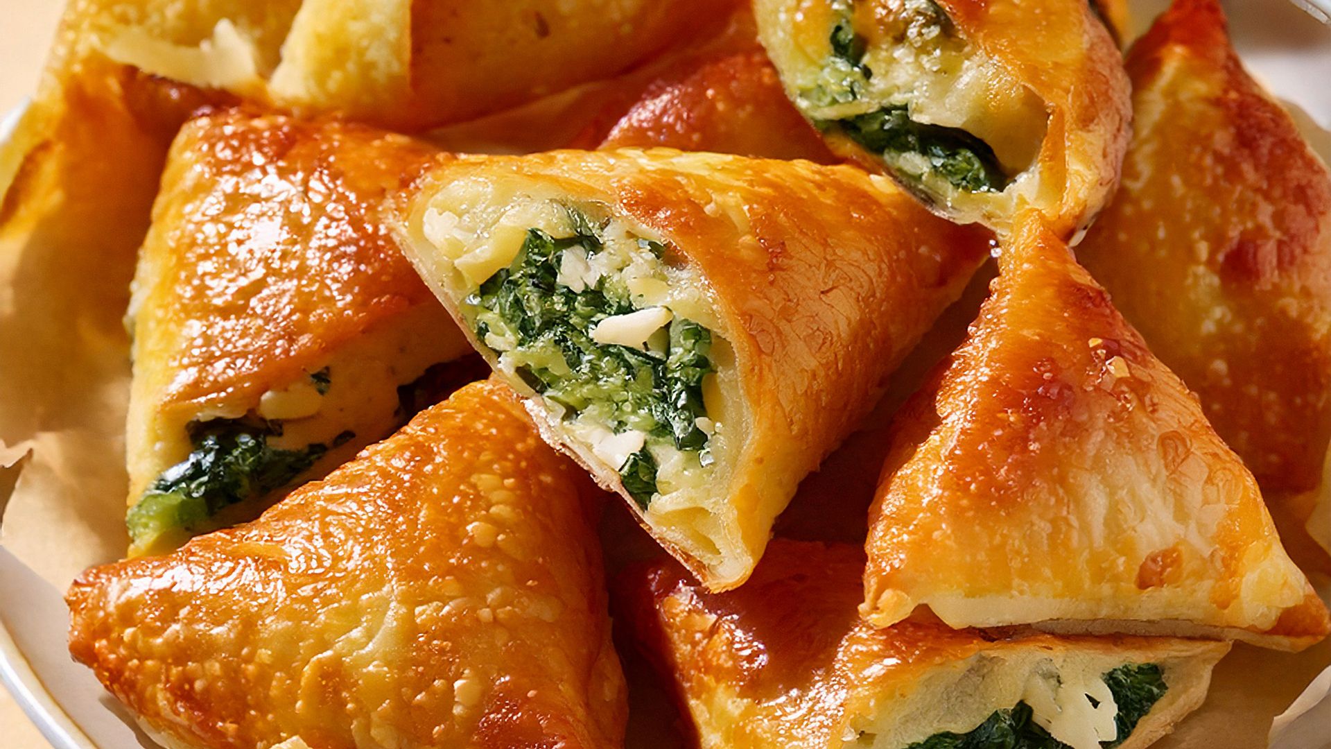 Empanadillas rellenas de espinacas con queso feta de forma triangular
