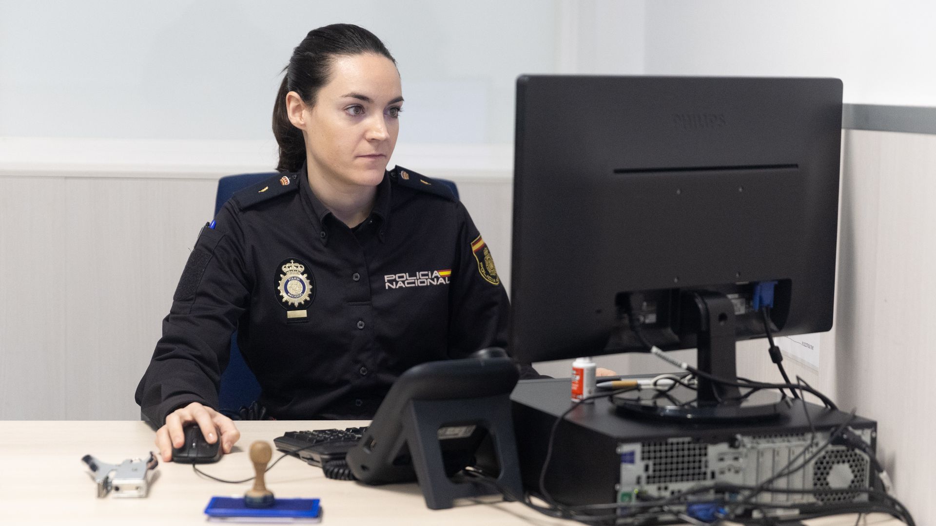 Policía Nacional en su despacho, trabajando en el ordenador