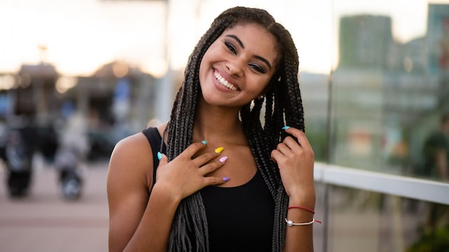 Mujer con camiseta negra y cabello largo con trenzas africanas
