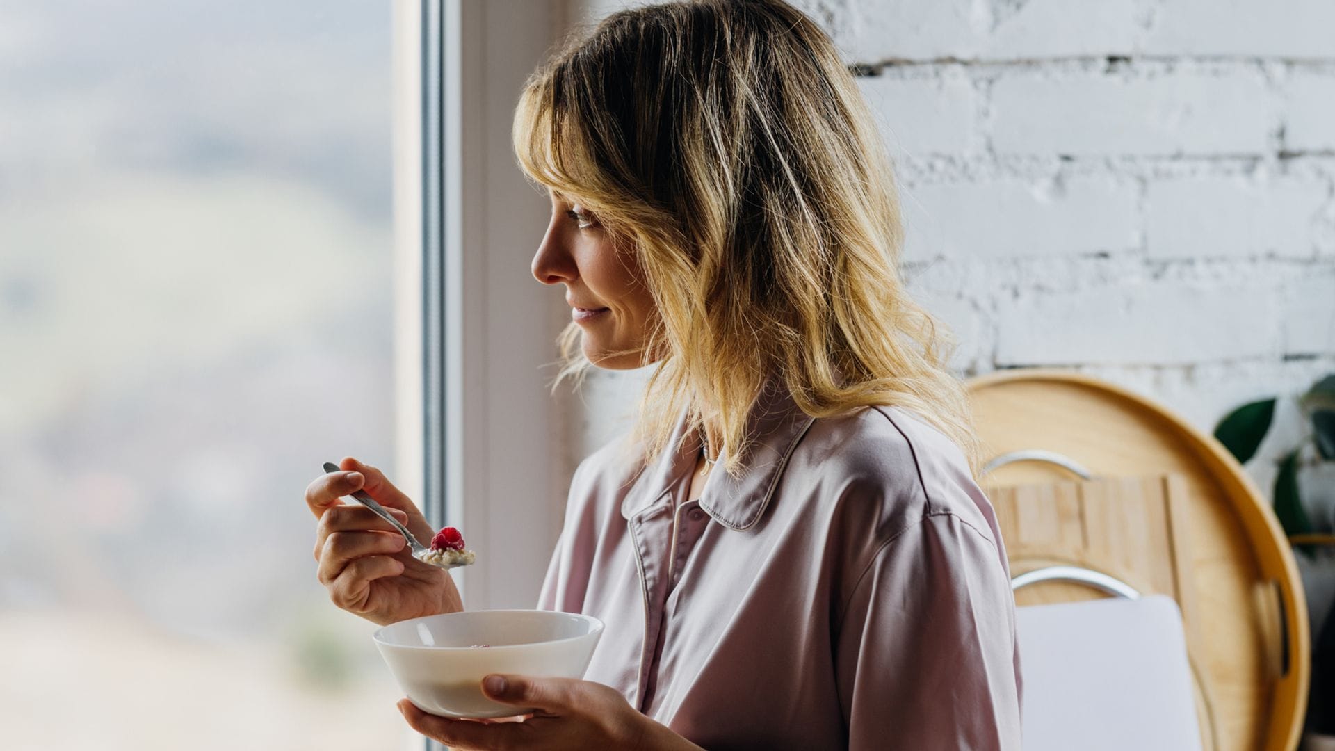 Una mujer disfrutando de un bol de desayuno con semillas de chia