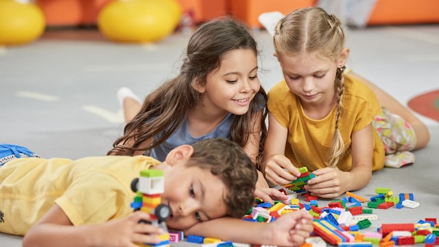 Niños jugando con juguetes en el suelo