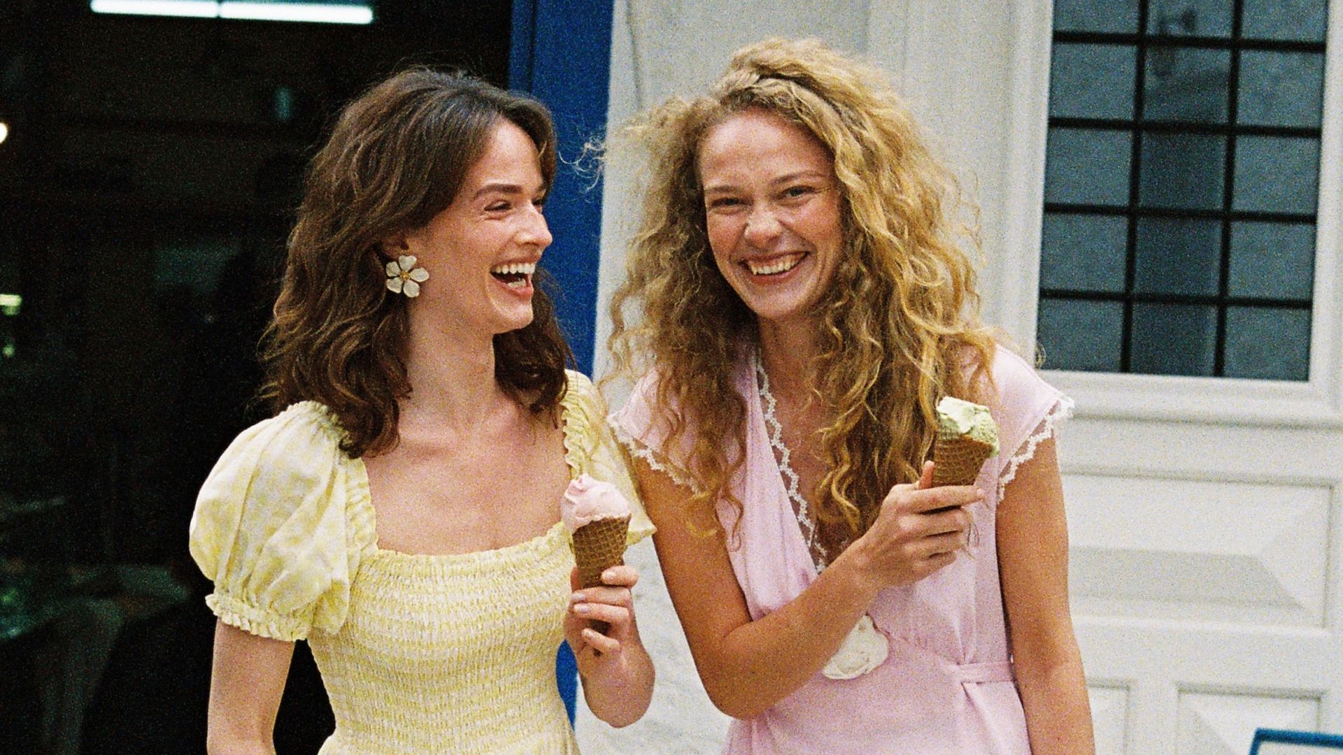 Dos amigas con helados pasándolo bien y riéndose