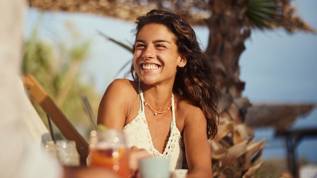Mujer feliz cenando en la playa