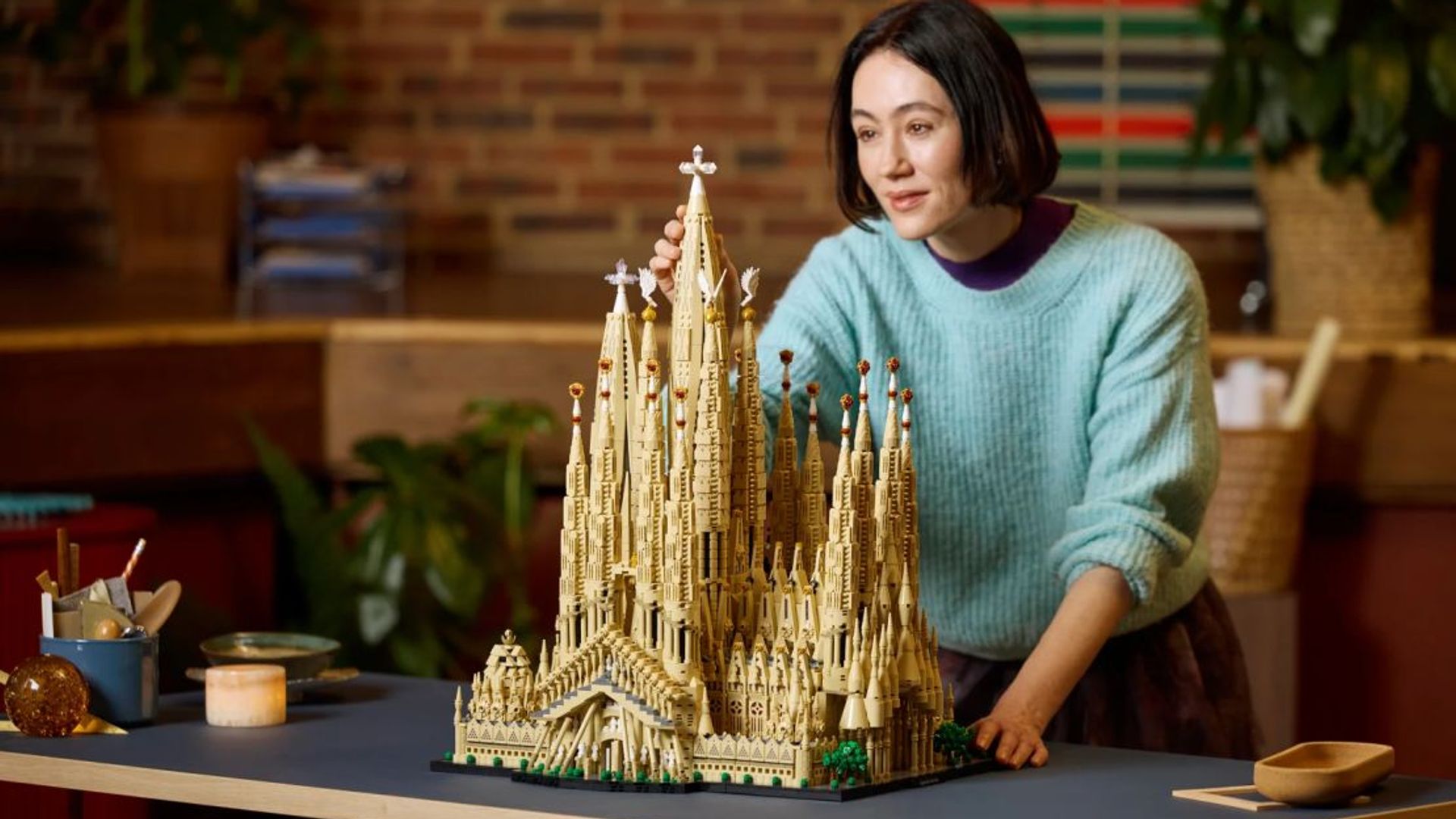 LEGO Sagrada Familia. Mujer terminando de construirlo.