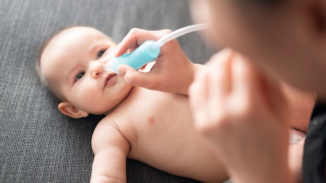 Una madre extrae mocos a su bebé