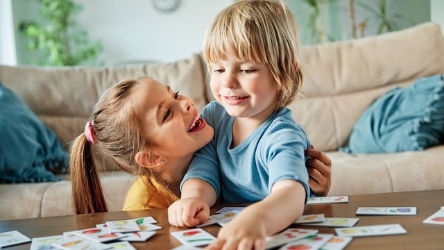 Hermanos jugando a un juego de mesa en casa
