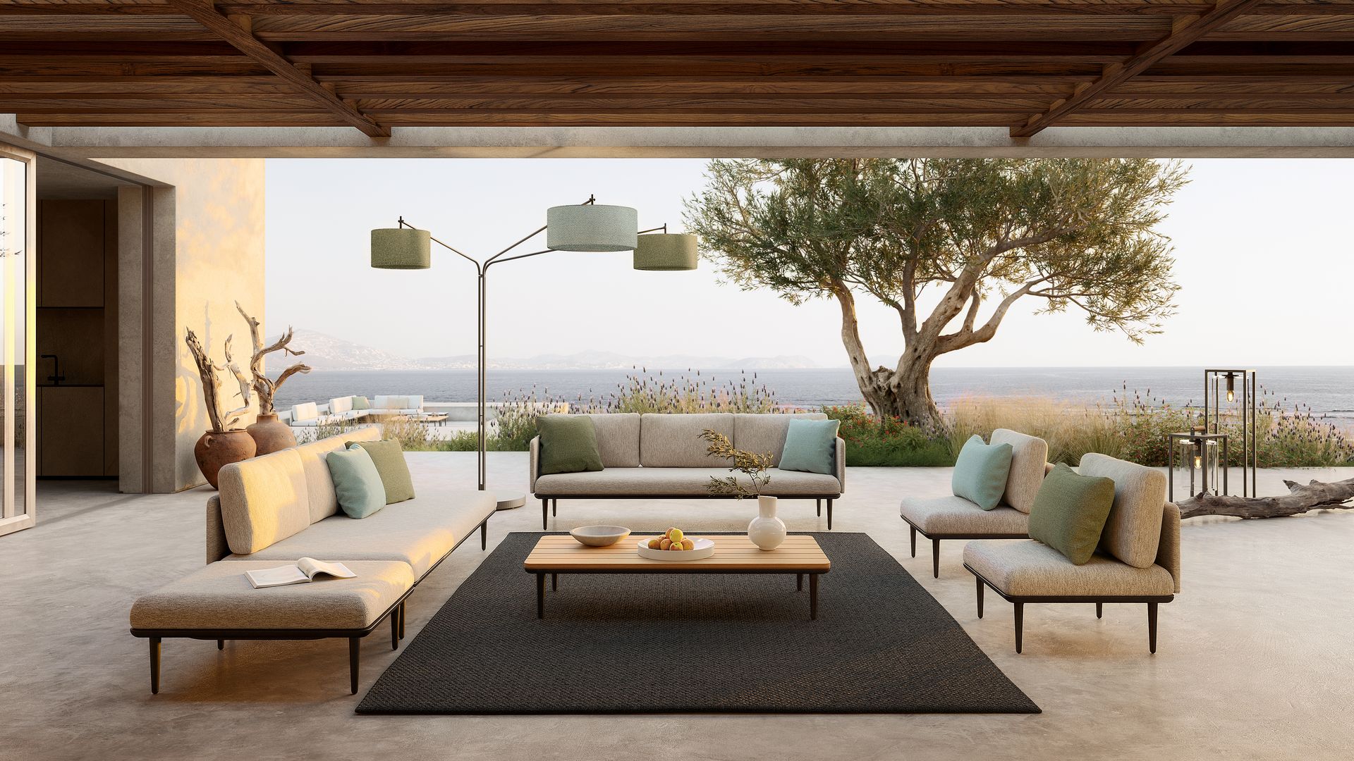 Salón exterior con sofás beiges, alfombra negra, lámpara de pie, mesa de centro, gran árbol