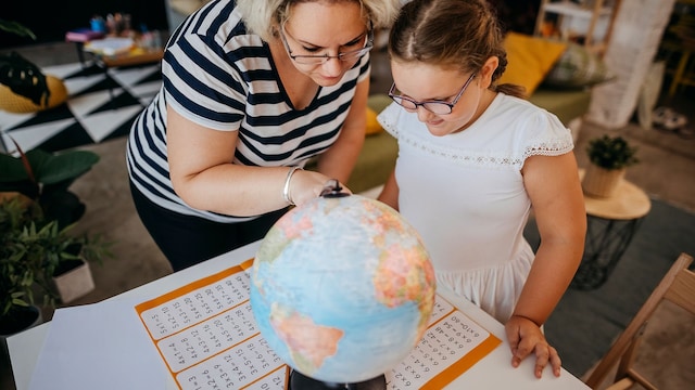 Madre e hija observan un globo terráqueo