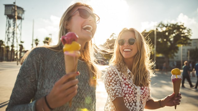 dos amigas felices en verano comiendo un helado