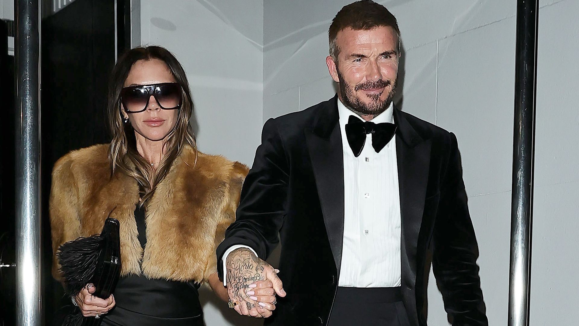 Sir David Beckham y su esposa Victoria saliendo del festejo de su título de Caballero, en Chelsea.