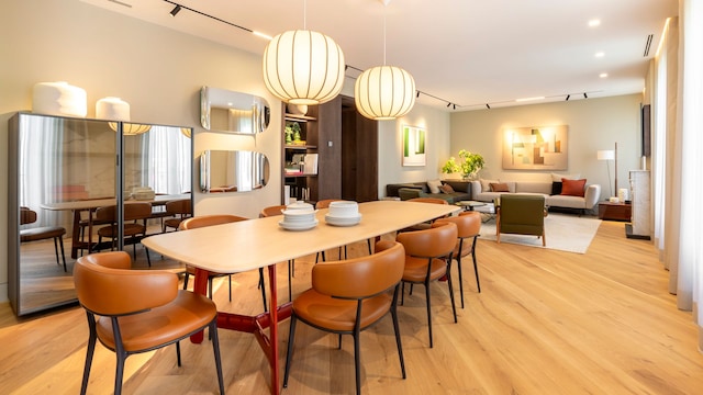 Comedor con mesa de madera alargada, sillas de cuero, dos lámparas e techo escultura, un armario con puertas de cristal