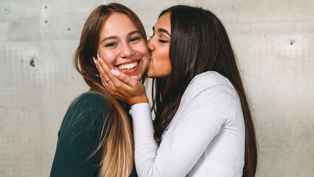 dos amigas dándose un beso en la mejilla