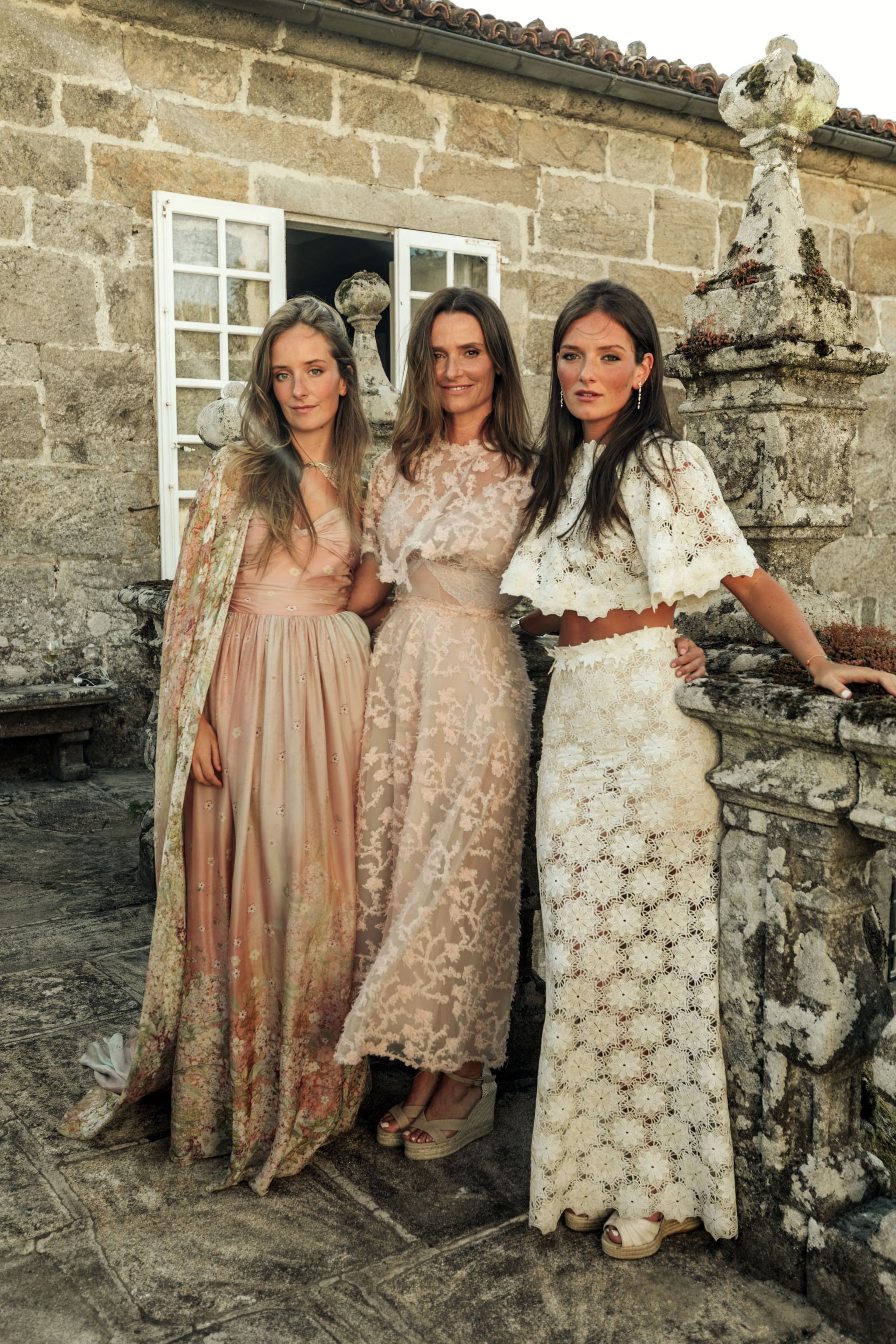 María del Prado con sus dos hijas, aunque bien podrían parecer hermanas. Las tres, con vestidos con motivos florales diseñador por la italiana Luisa Beccaria, que evocaban al aire casi onírico del espacio en el que tuvo lugar la celebración, el Pazo de Oca, una finca erigida sobre un fortín en el siglo XV que, después, se vio modificado en estilo barroco y es considerado el Versalles gallego por sus espléndidos jardines inspirados en los que Le Notre diseñó para el Rey Sol