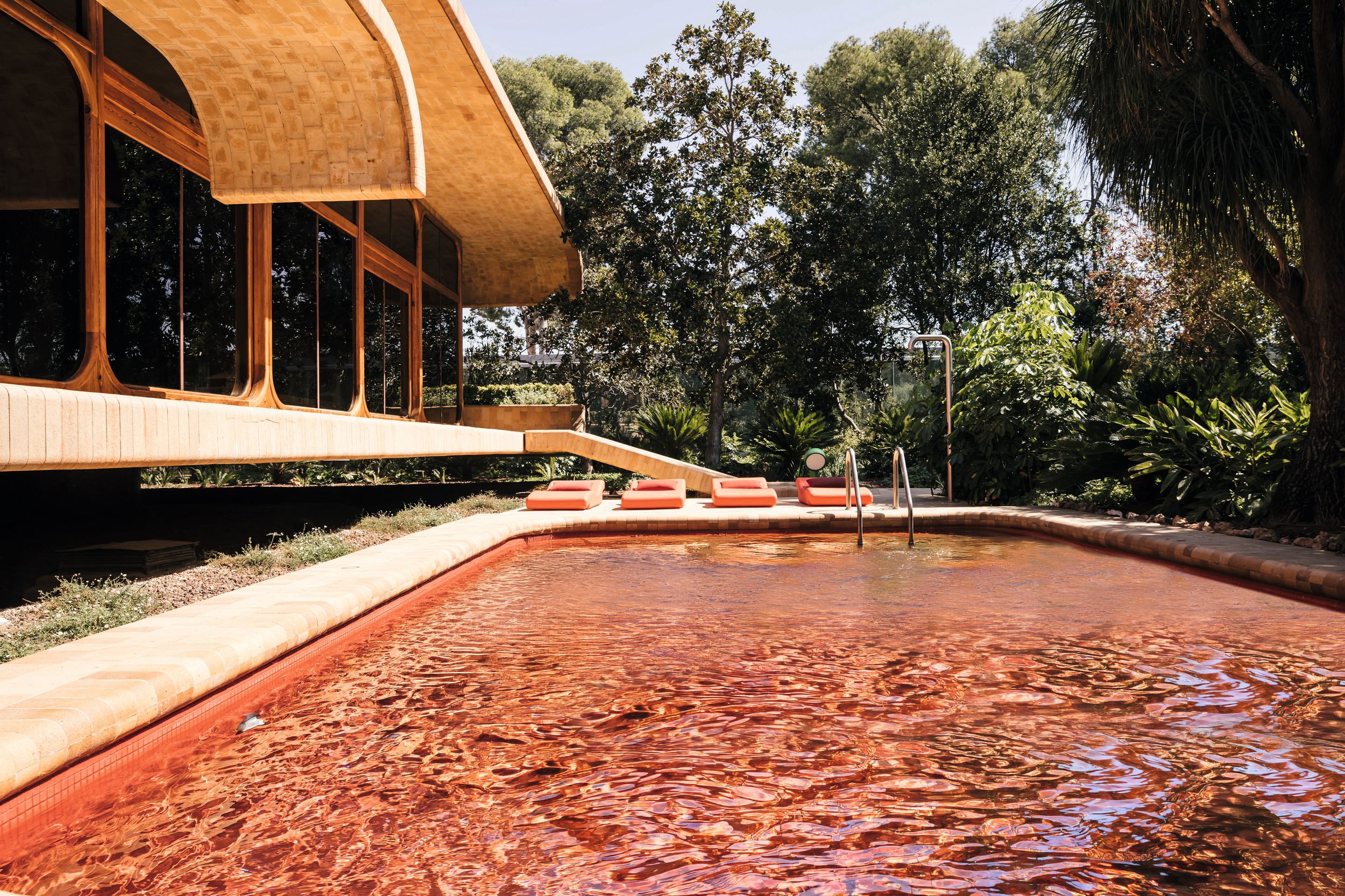 La piscina exterior, en una superficie monocromática roja muy intensa