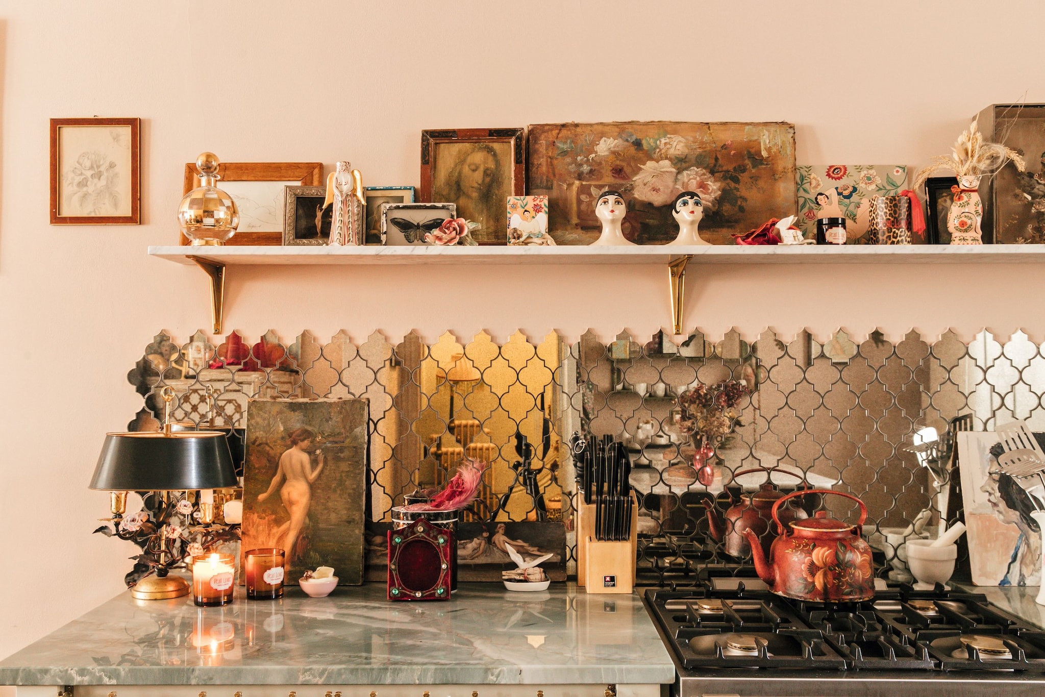 Cocina con estantes decorados, cuadros, y una repisa con objetos