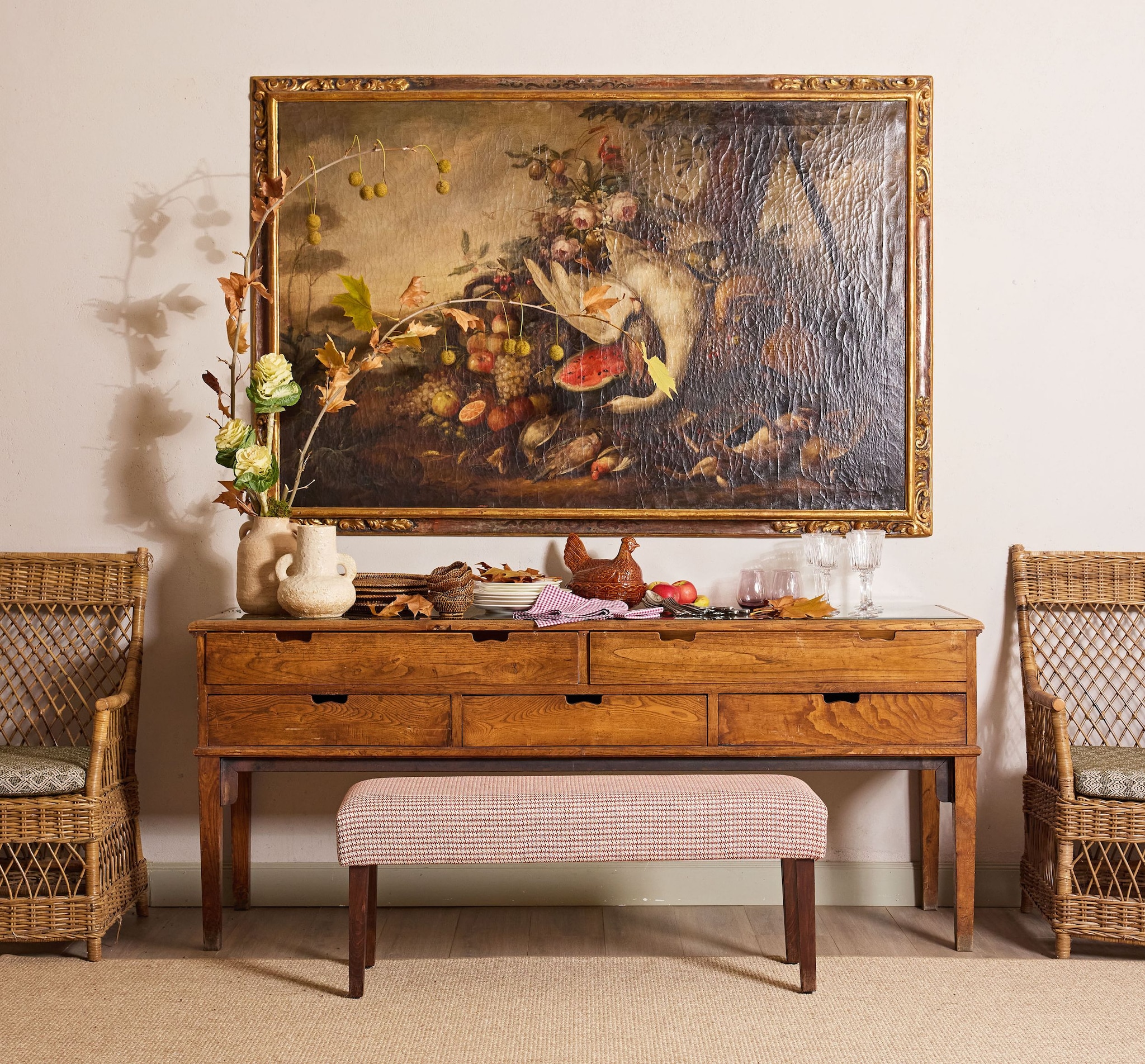 Una de las estancias con un cuadro de un bodegón y un mueble de madera