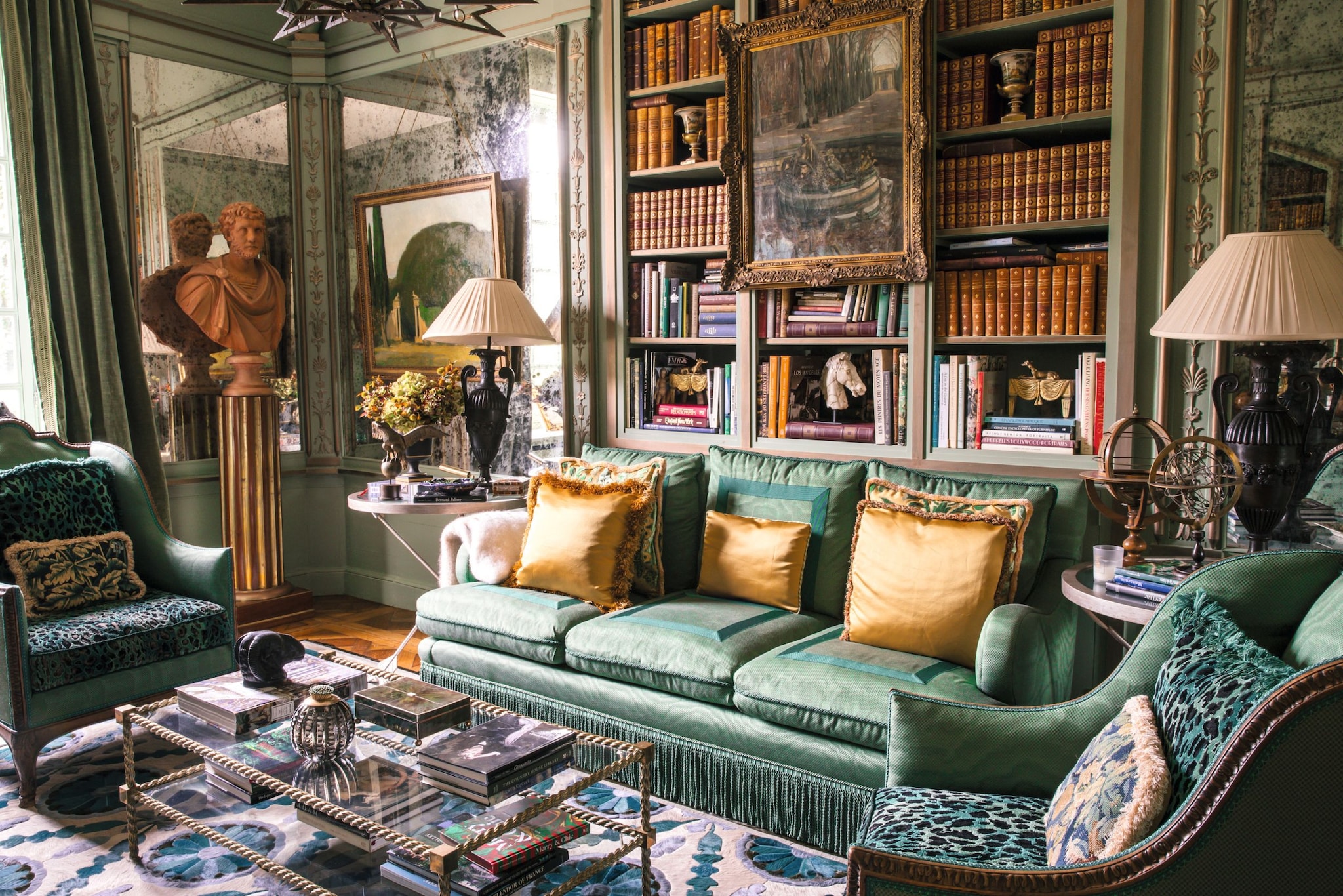 Sala de estar elegante con sofá verde, cojines amarillos, biblioteca y sillas verdes.