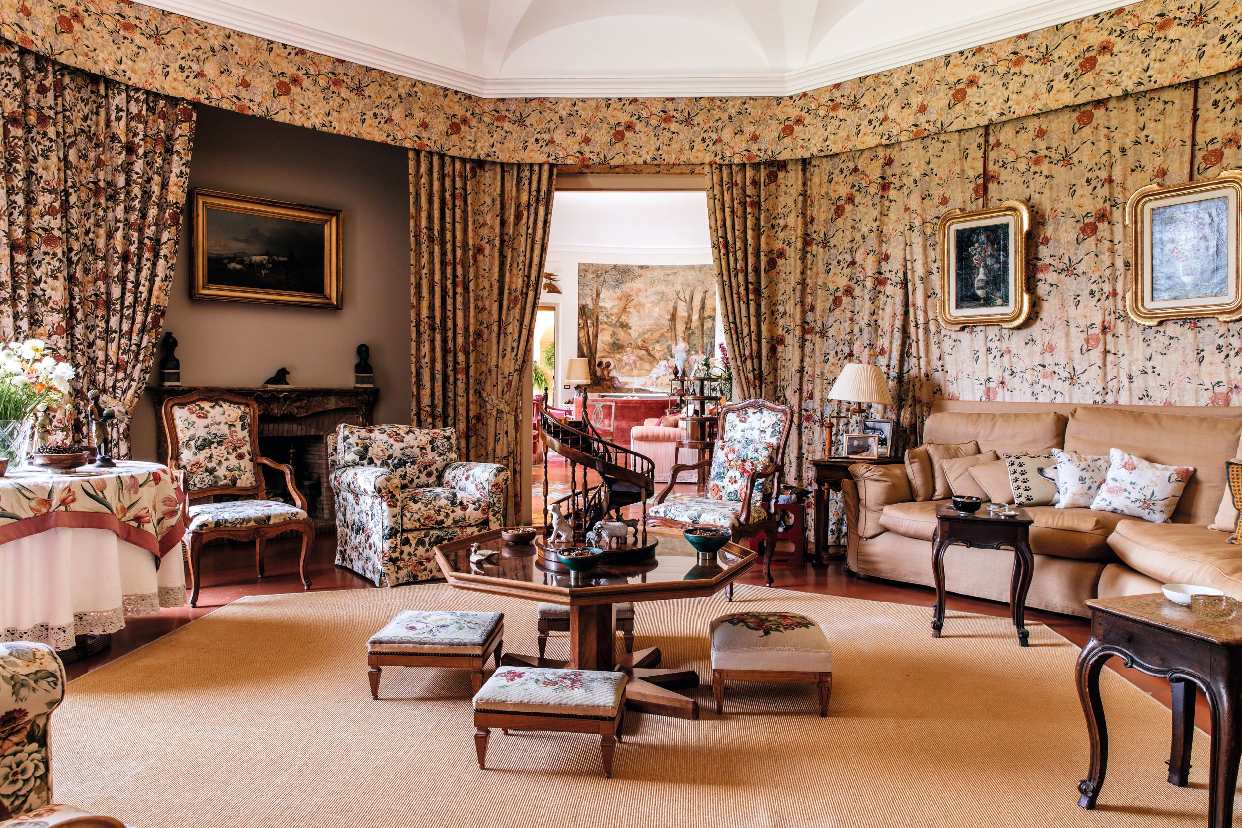 Uno de los impresionantes salones de la casa de Maria Sole Torlonia con sillones color camel y papel estampado