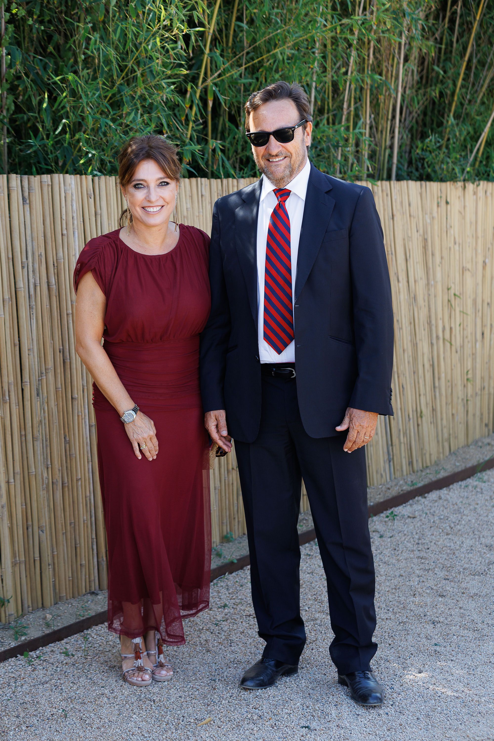 Helena Resano, junto a Aitor Aristegui, con un vestido burdeos de caída fluida.