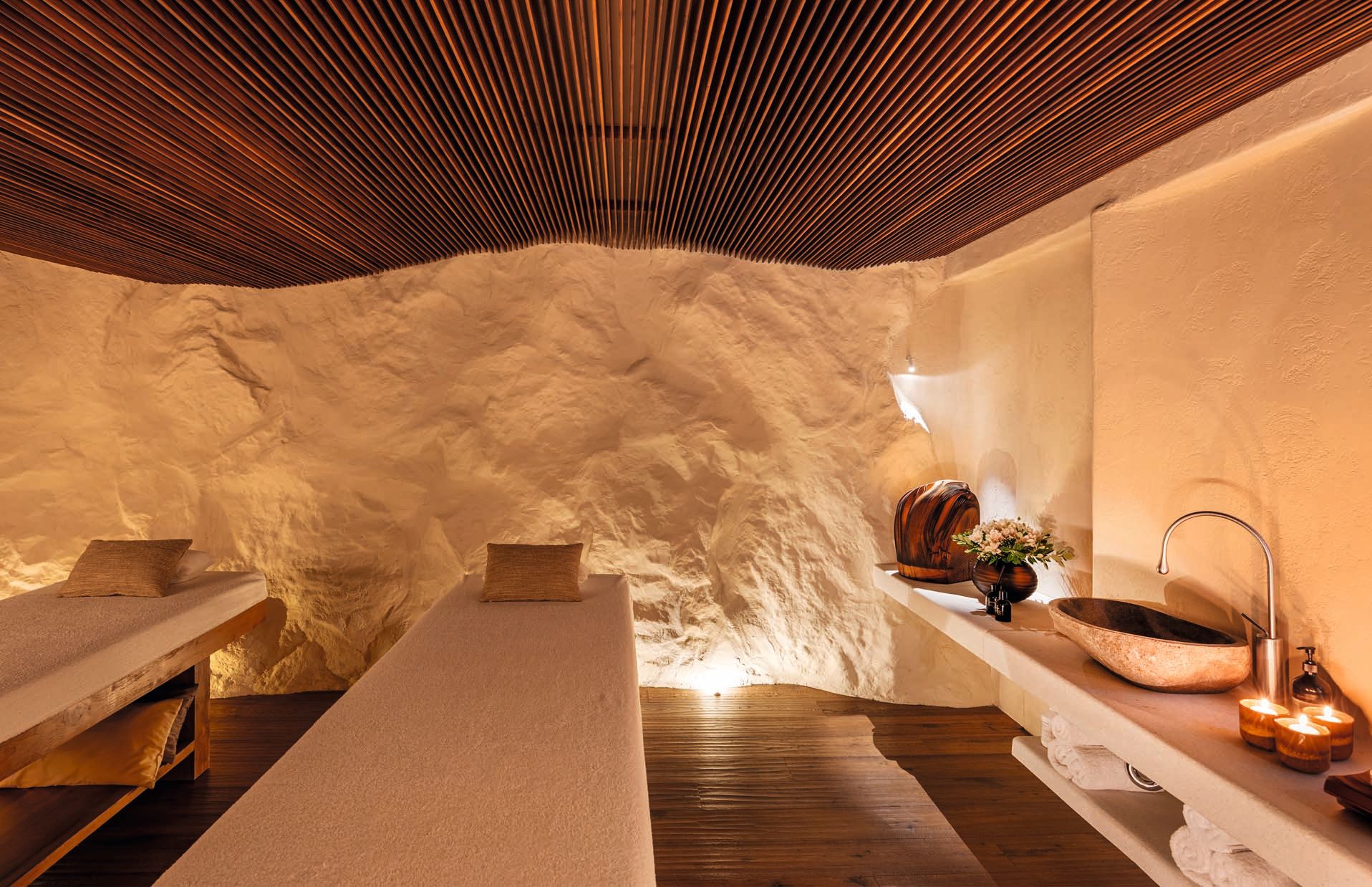El "spa" esculpido en la roca natural, con techo elaborado con listones de madera ondulados que evocan el movimiento de las olas