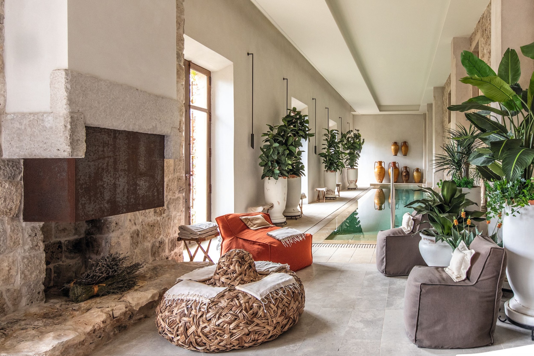 La piscina interior, climatizada, con una chimenea