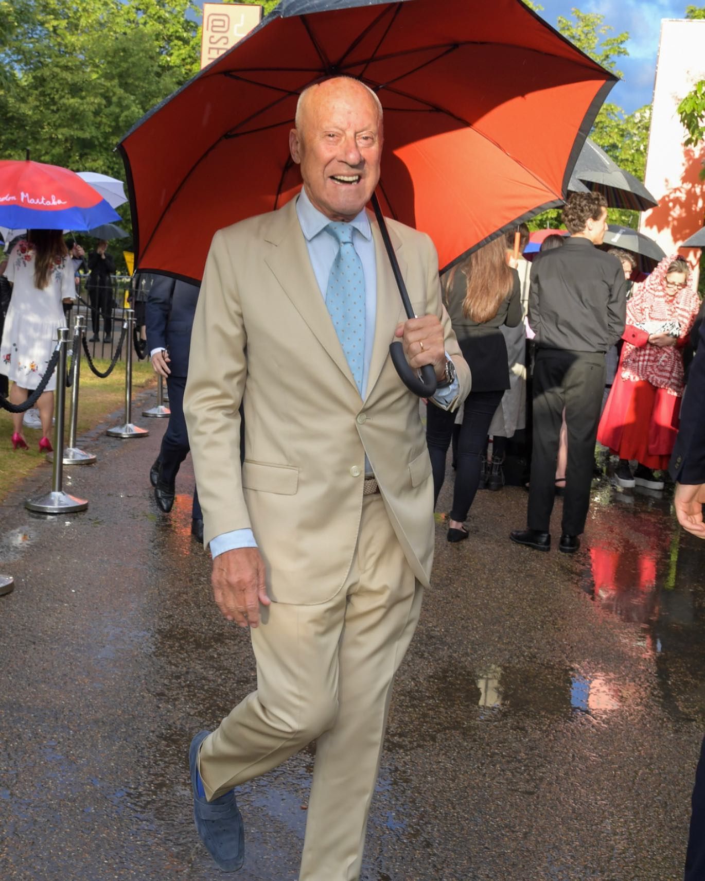 Norman Foster riendo con paraguas