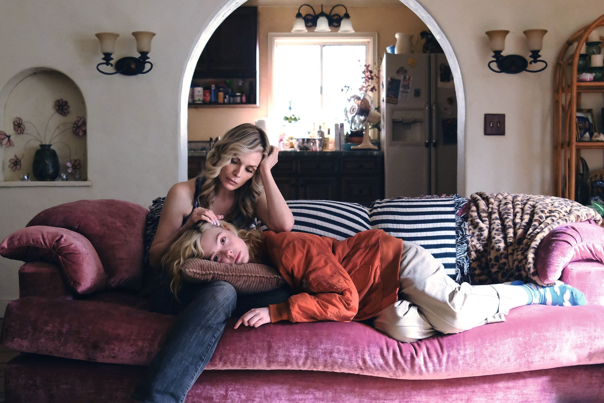 Elle Fanning yace en un sofá con una mujer, ambas parecen estar cansadas.
