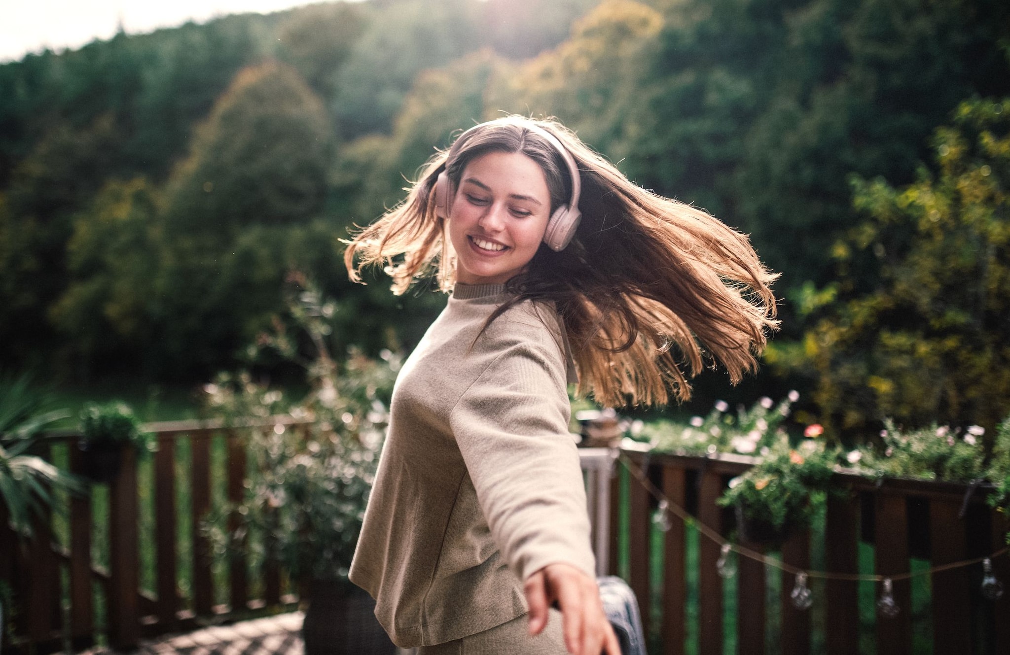 Mujer escuchando música en una terraza en la montaña