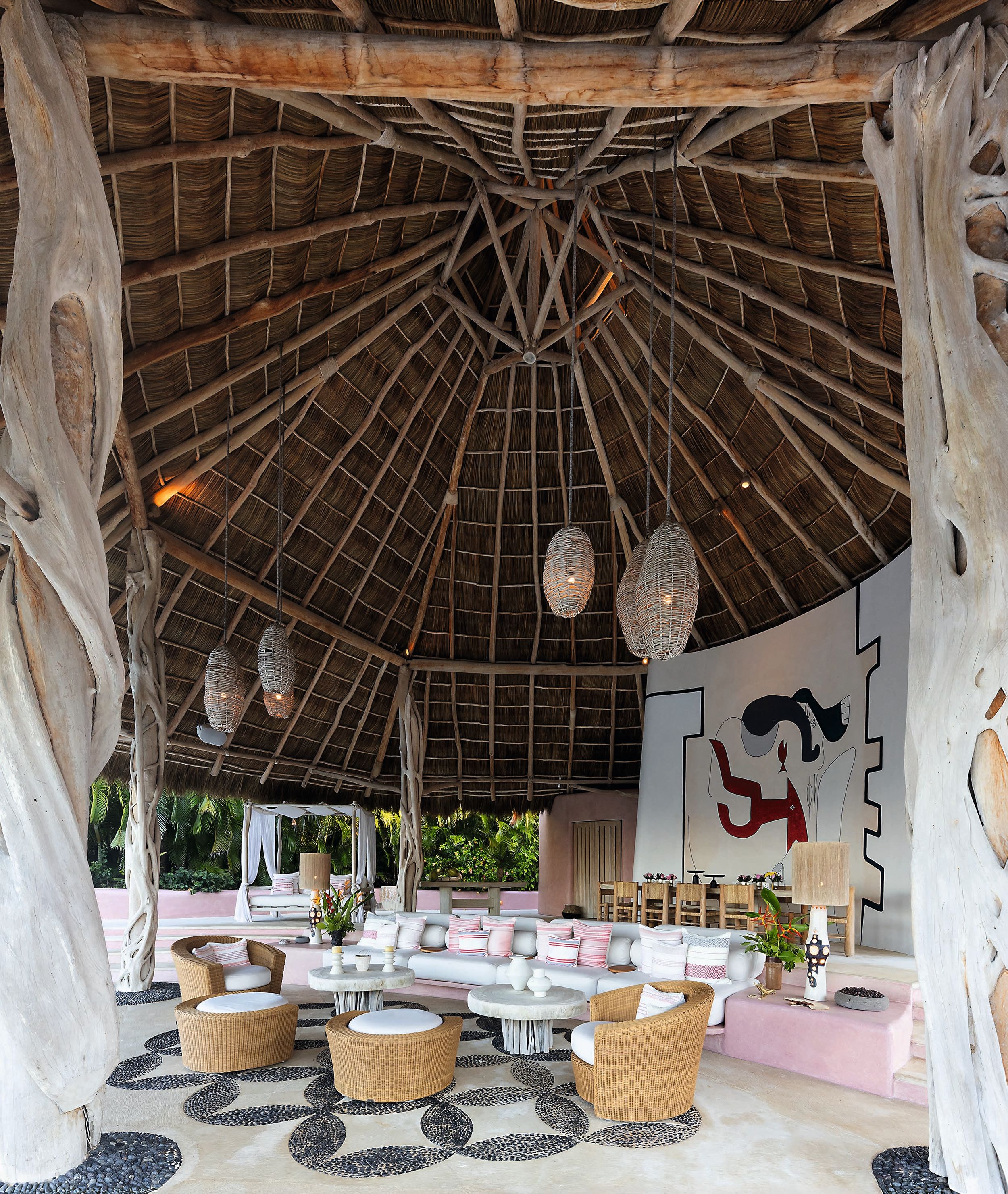 La villa, de cinco dormitorios, tiene tres terrazas, una de las cuales ejerce de salón exterior. Con una altura de nueve metros y cubierto con una palapa que se sostiene sobre columnas de madera de bejuco cubierta de ramas de viña, consta de numerosos asientos para los invitados, desde sofás curvos empotrados y adornados con cojines de rayas rosas hasta sillones de ratán