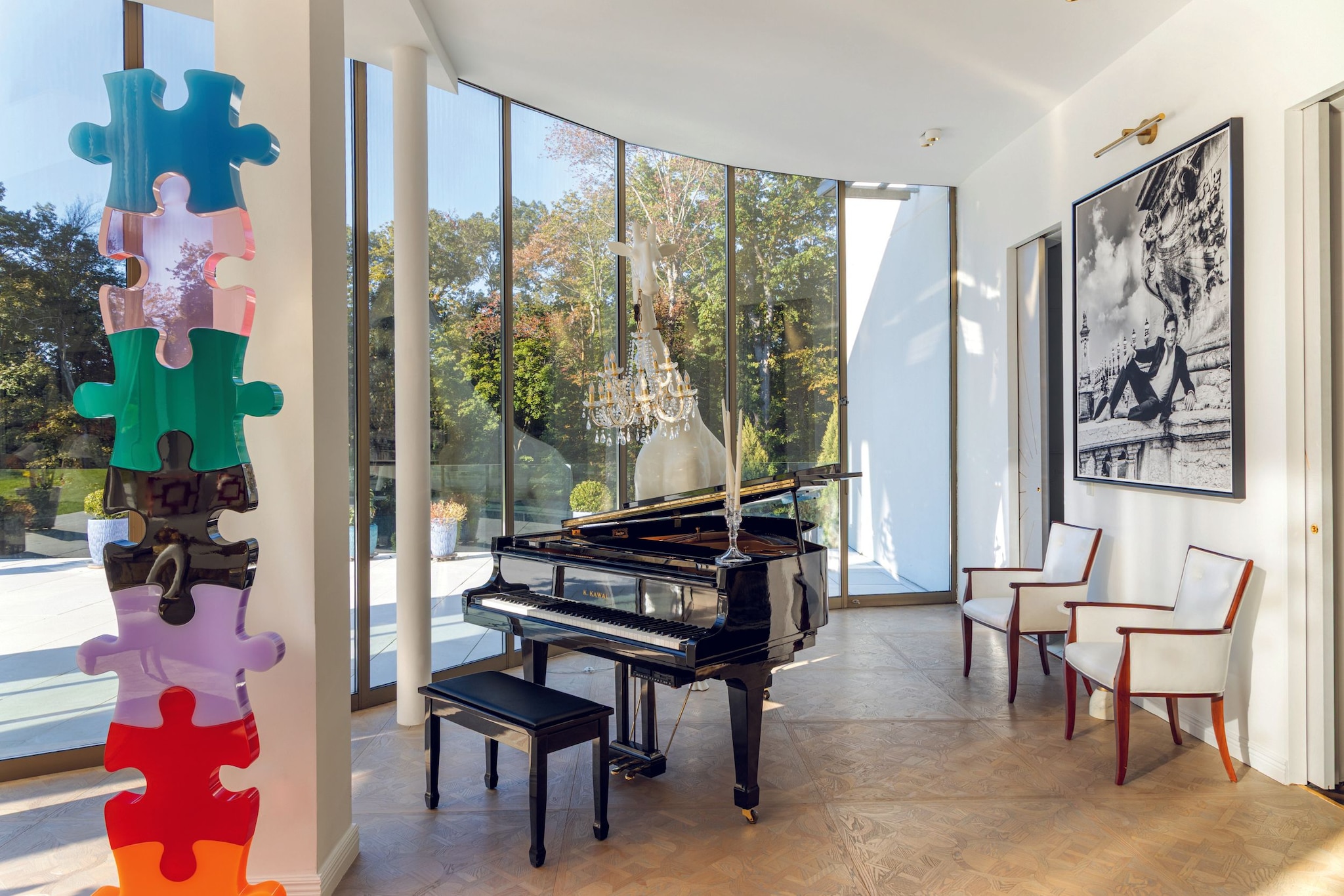 Sala con piano, dos sillas, y una pintura de un hombre en traje.