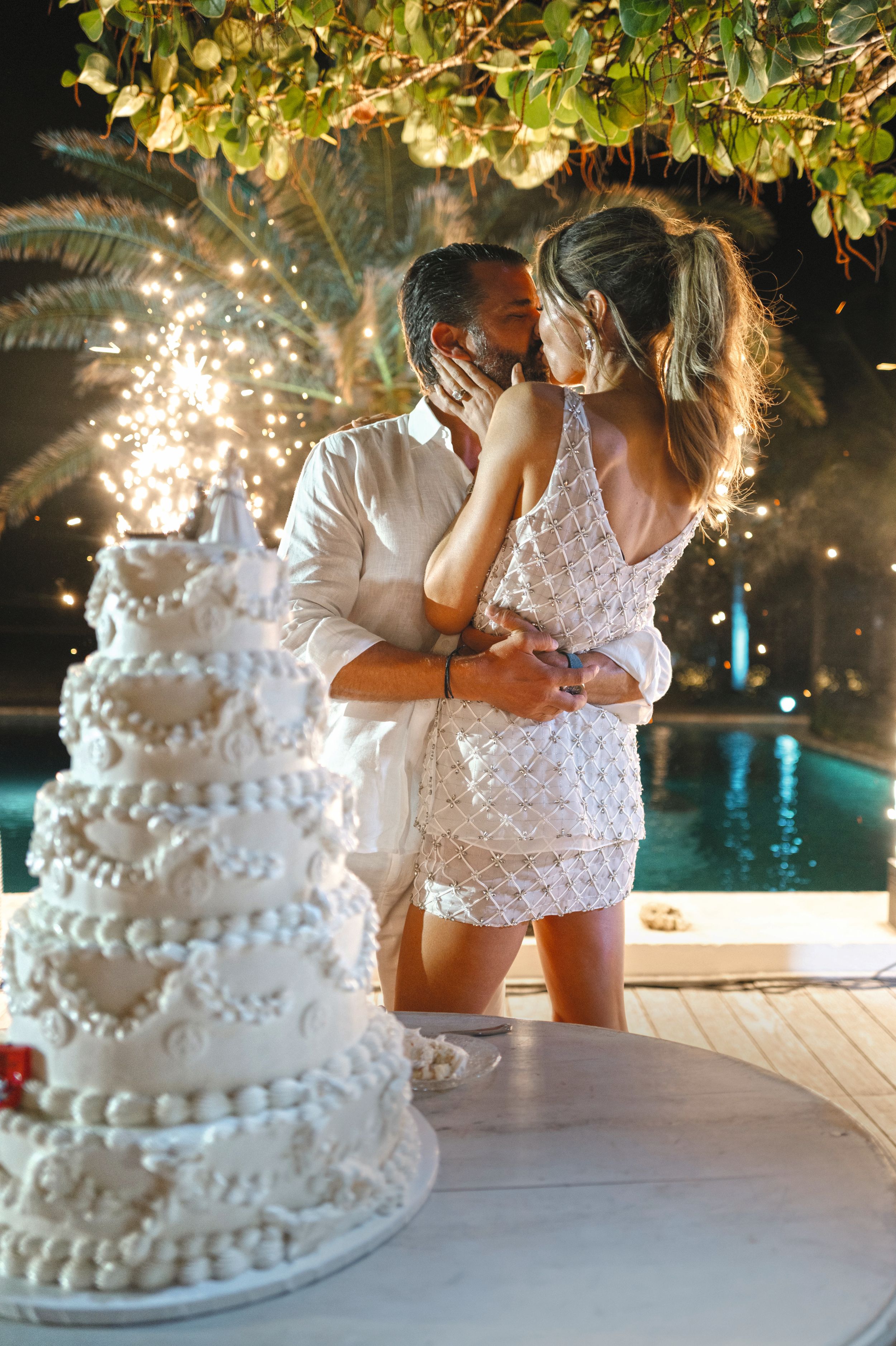 La pareja junto a la tarta nupcial. La novia lució un segundo "look" de dos piezas, de Safiyaa