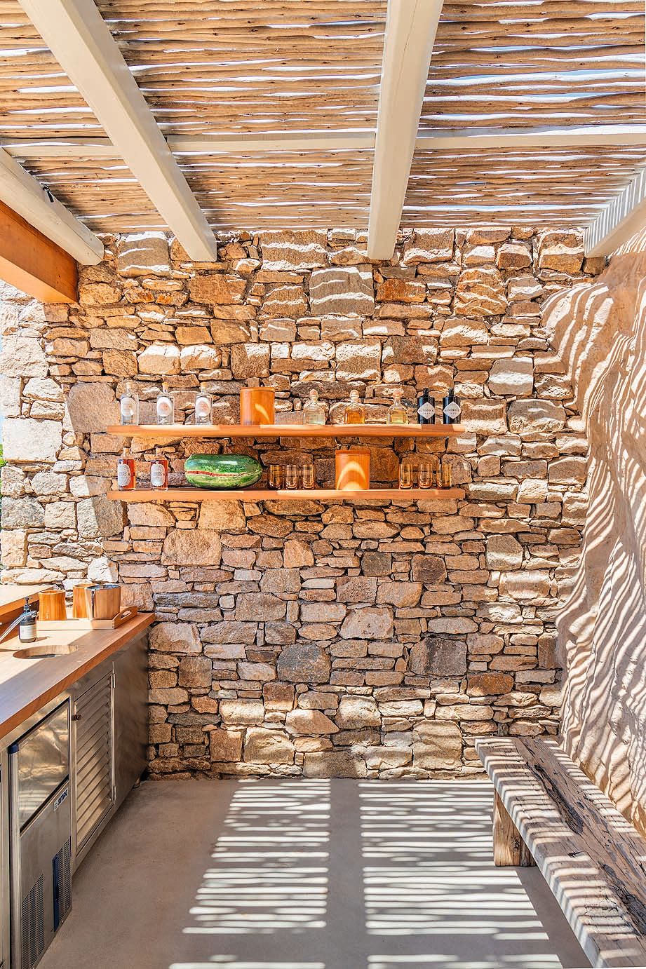 Dos imágenes de la caseta de la piscina, con piedra natural y postes de bambú