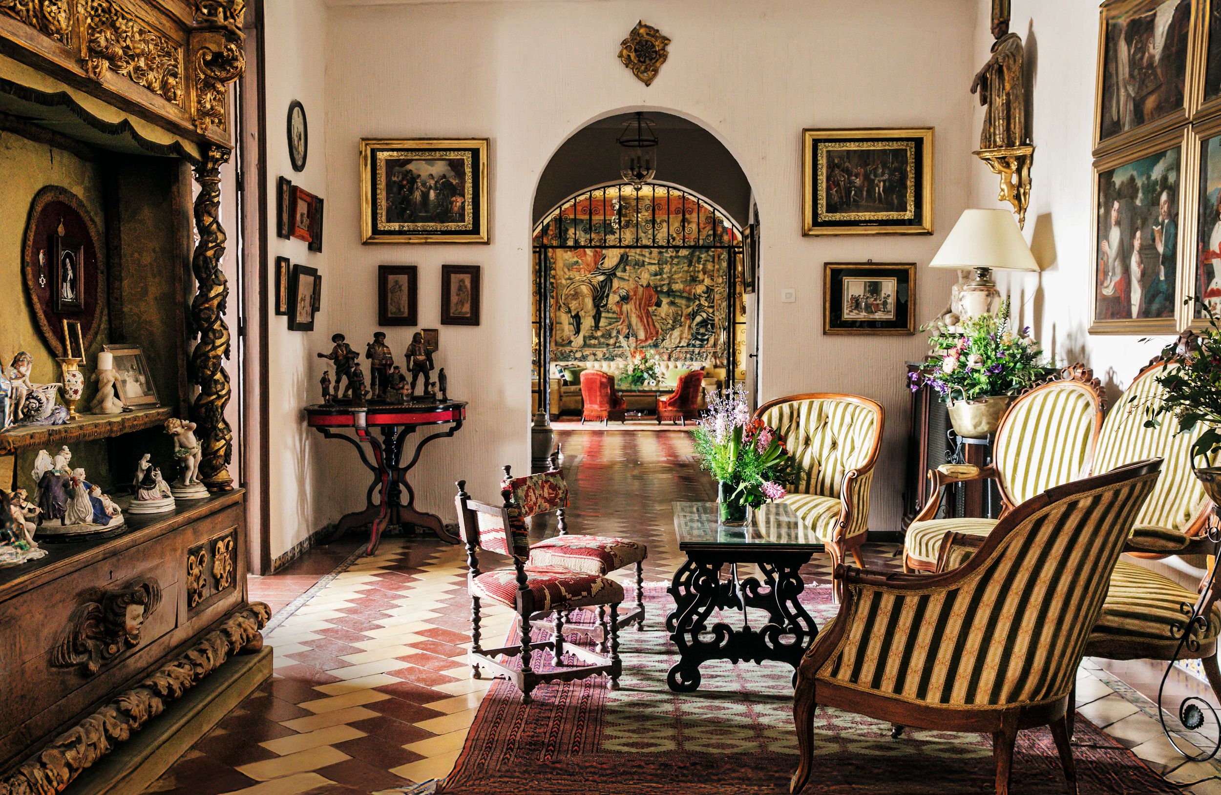 Salón con mueble sacristía del siglo XVIII, con porcelana francesa (izquierda), mesa redonda con figuras flamencas de terracota de la escuela granadina