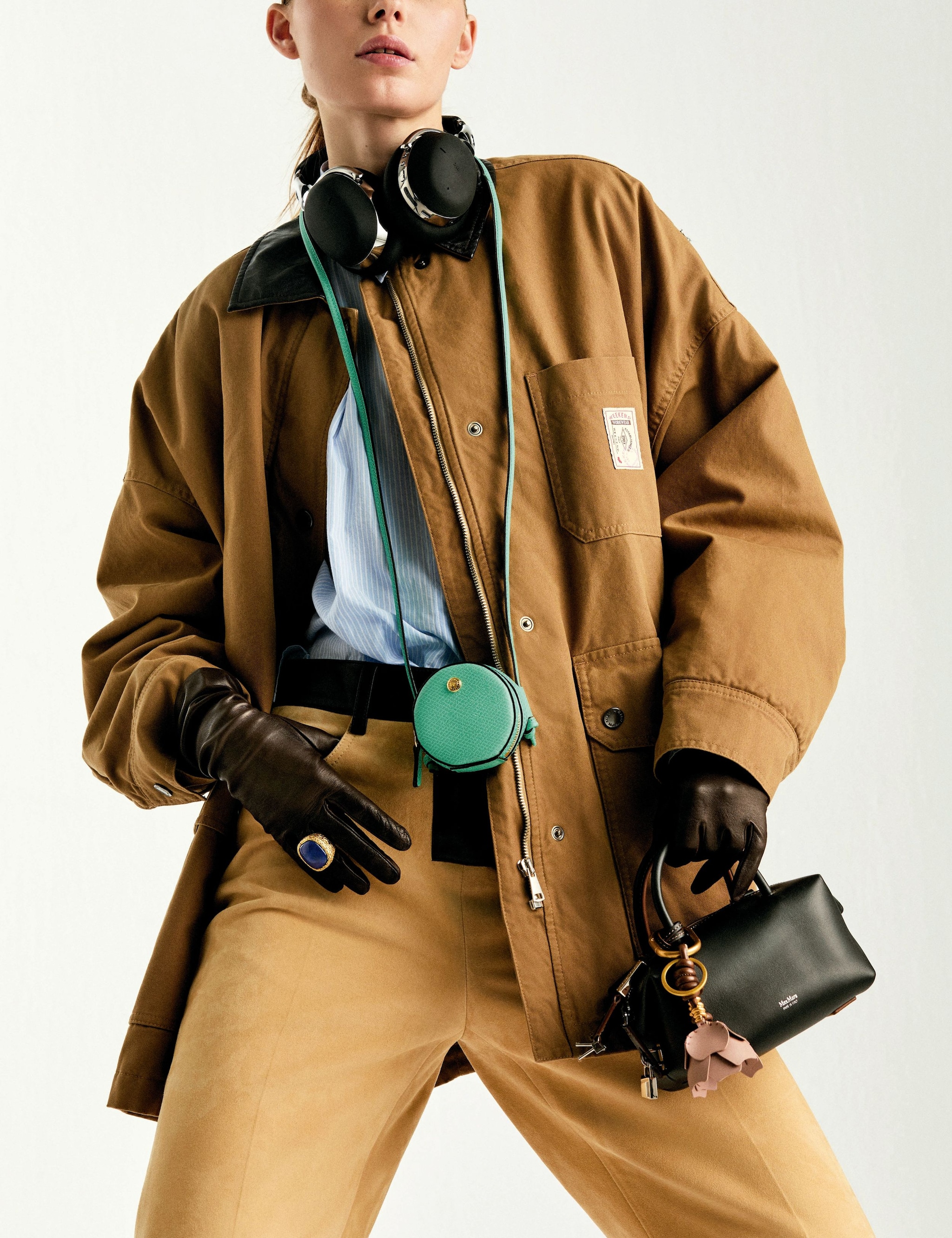 La modelo lleva chaqueta, de Weekend Max Mara; camisa, de American Vintage; pantalón, de Ferragamo; bolso de mano, de Max Mara; minibolso verde, de Longchamp; llavero, de Gianni Chiarini; auriculares, de Montblanc; guantes, de Guante Varadé, y anillo, de Aurélie Bidermann