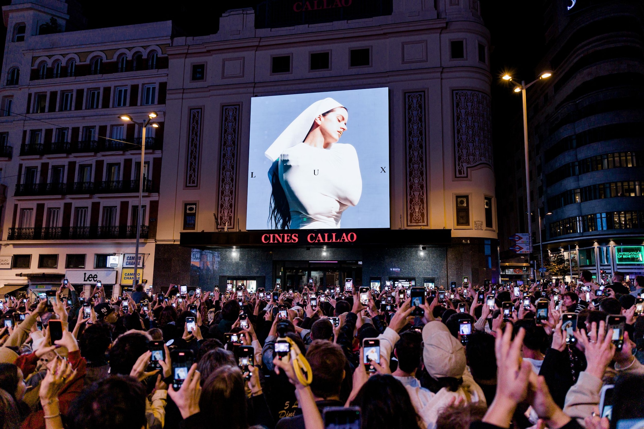 MADRID, SPAIN - OCTOBER 20: Dozens of people look at the cover of Rosalia's new album, 'Lux', at the Plaza de Callao, on 20 October, 2025 in Madrid, Spain. Catalan singer Rosalia has appeared in Madrid's Callao square by surprise to announce her fourth studio album will be called 'Lux' to be released on November 7, three years after the release of 'Motomami' in 2022. This has come after several images of an advertisement in New York's Times Square appeared on networks to share the release of his new project. (Photo By Carlos Lujan/Europa Press via Getty Images)