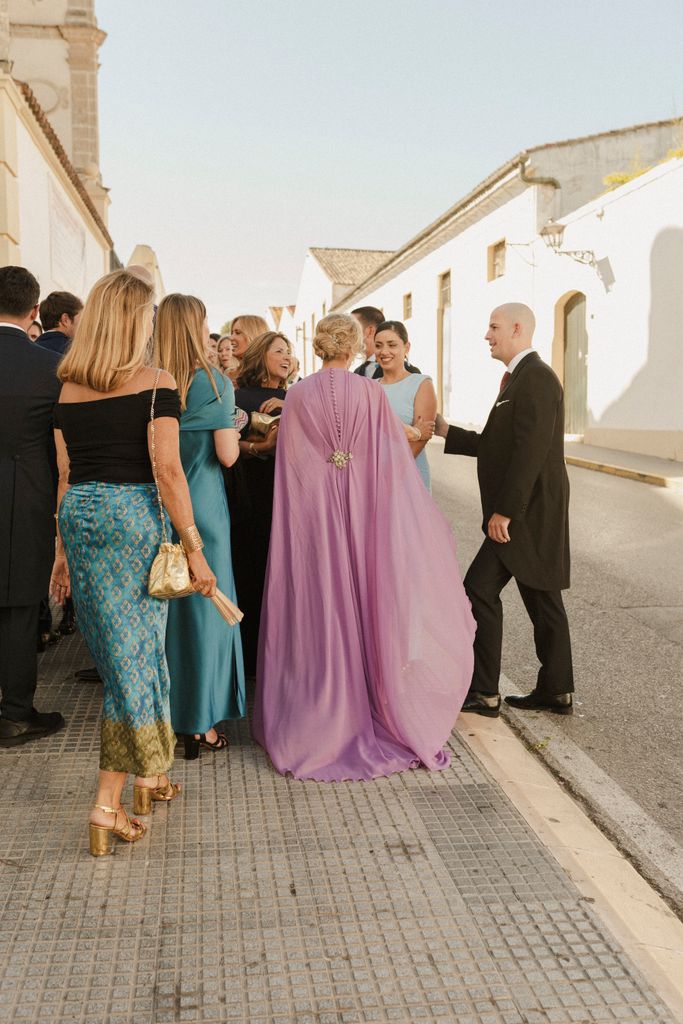 Madrina de boda con vestido satinado Elena Moore con capa desmontable