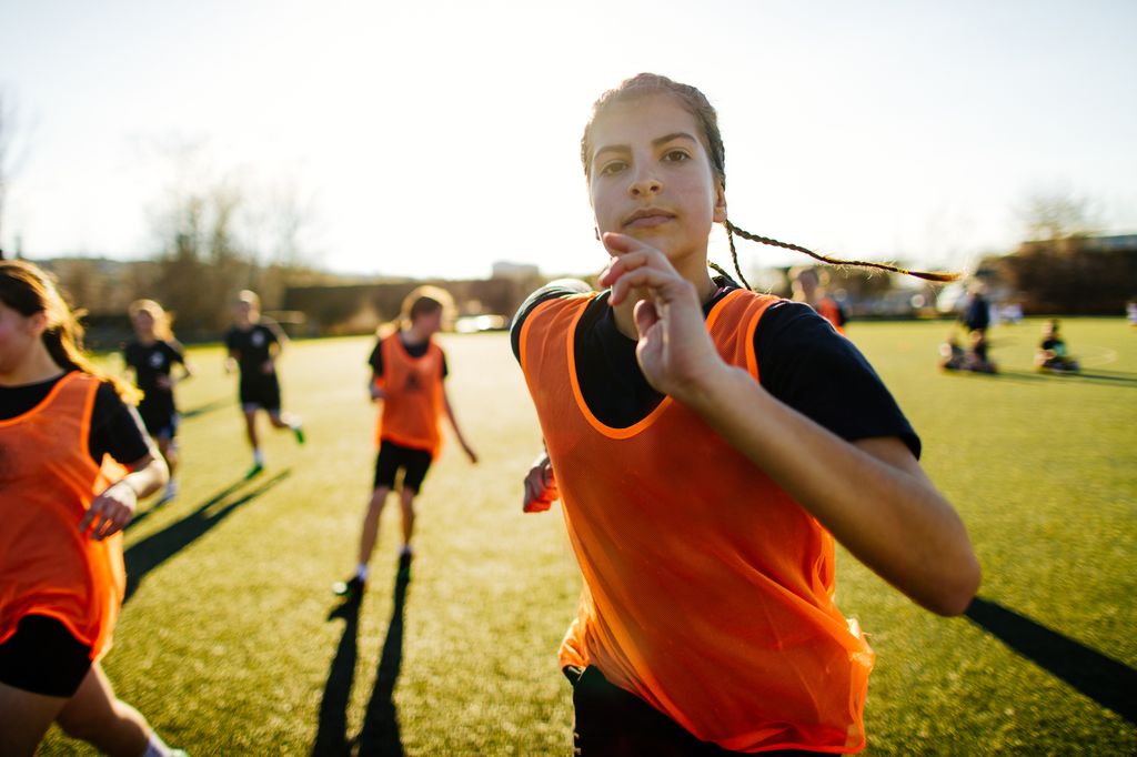 Chica adolescente entrenando en un campo de deportes