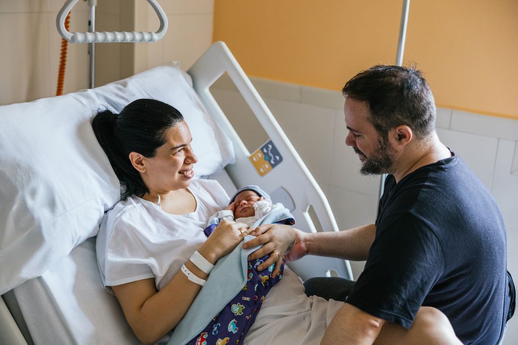 Madre con su bebé en el hospital y el padre del niño