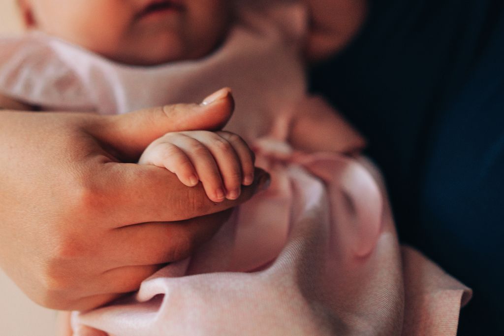 Madre cogiendo la mano de un bebé