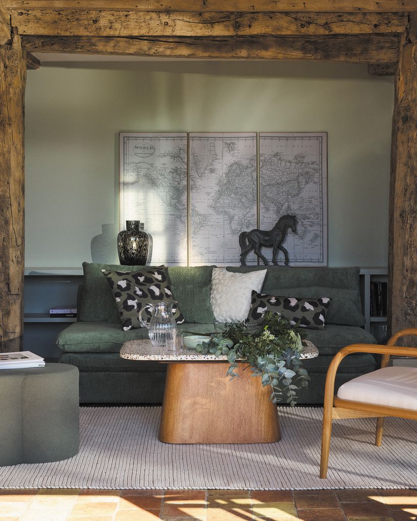 Salón con sofá verde y mesa de centro de madera y sobre de piedra