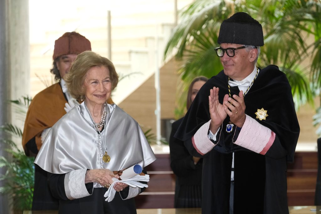 La reina Sofía con los guantes blancos y el diploma que ha recibido tras su distinción académica por la UPDG