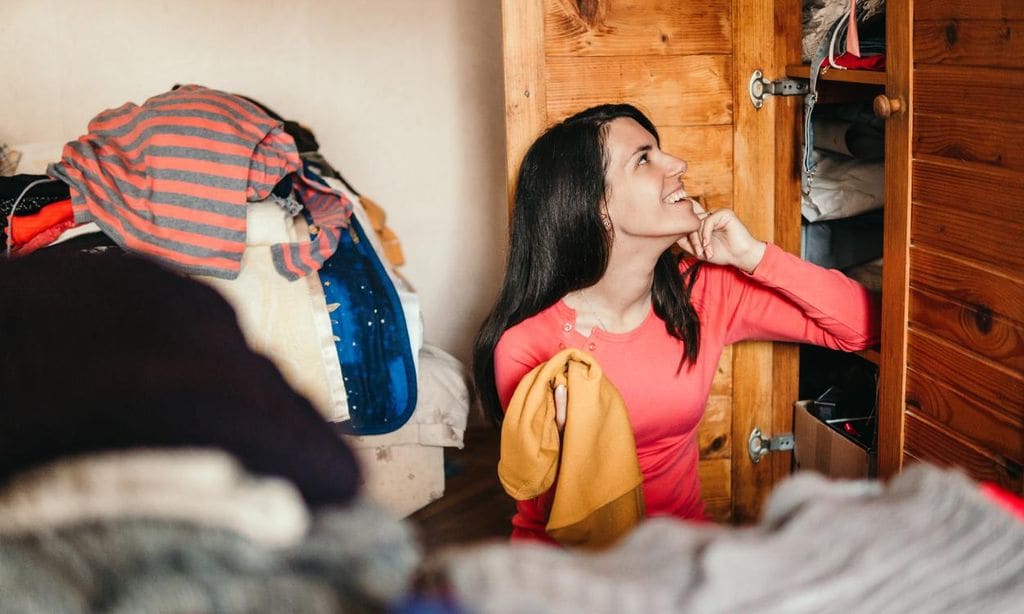 Mujer observando su armario para ordenarlo