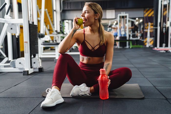 mujer deportista comiendo una manzana