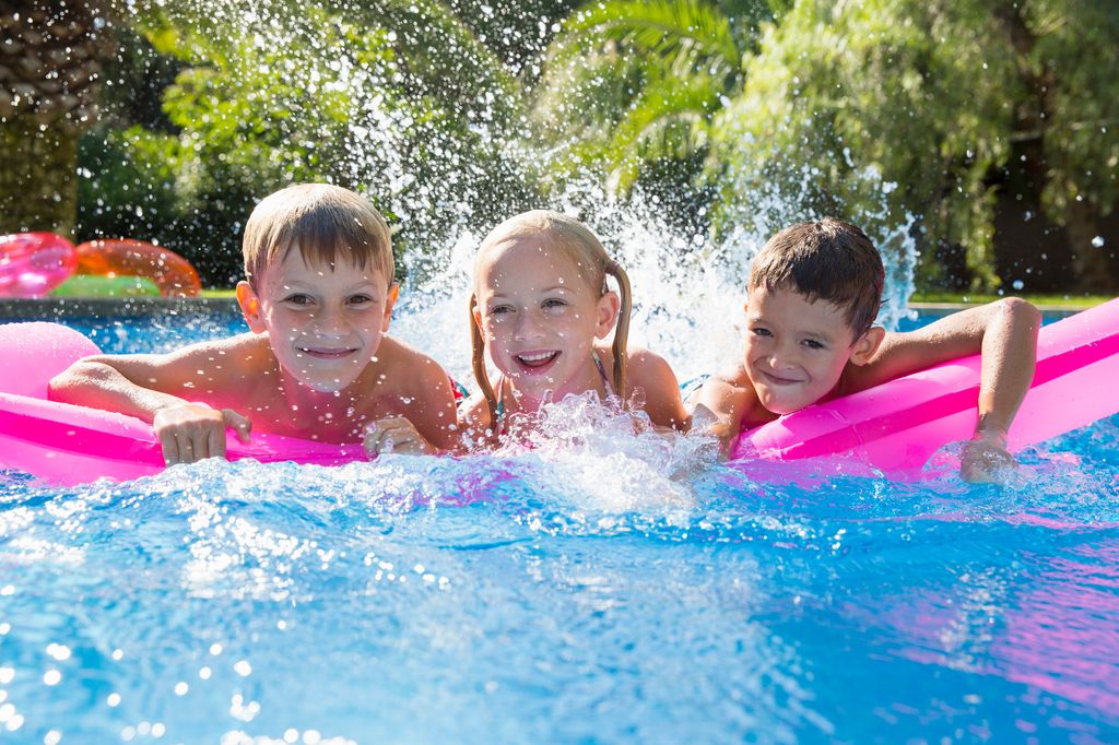 tres niños jugando en la piscina