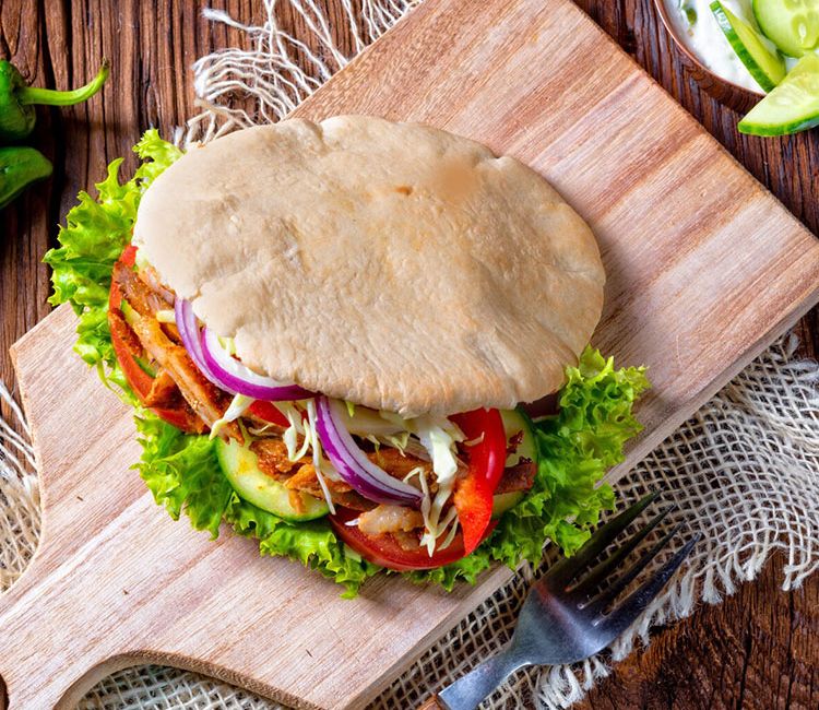 Sándwich de pan de pita con lomo adobado y 'tzatziki'
