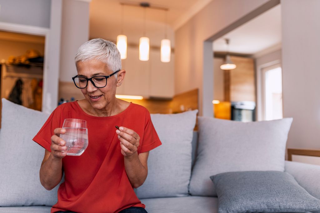 Mujer senior tomándose un medicamento