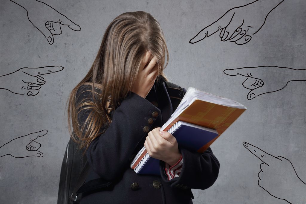 Adolescente tapándose la cara por fracaso escolar