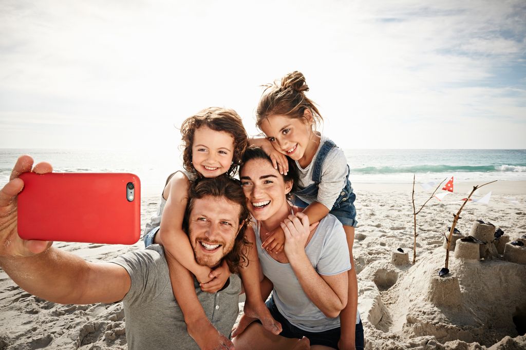 familia haciéndose un selfie en la playa