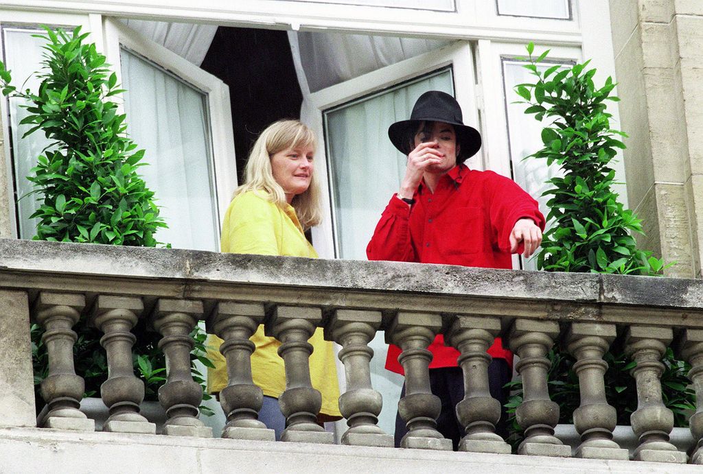 El cantante Michael Jackson y su esposa Debbie Rowe saludan a los fans desde el balcón del hotel Royal Monceau en París, en 1997.