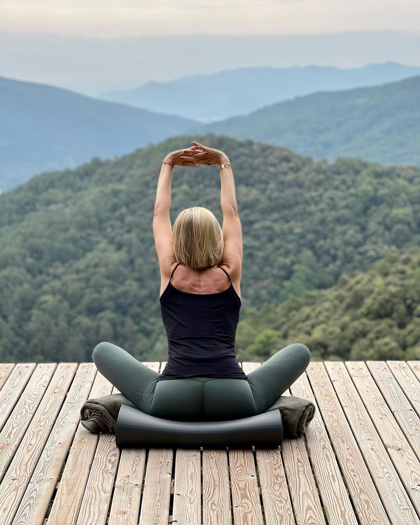 Judit Mascó practicando yoga en una masía en frente de la montaña